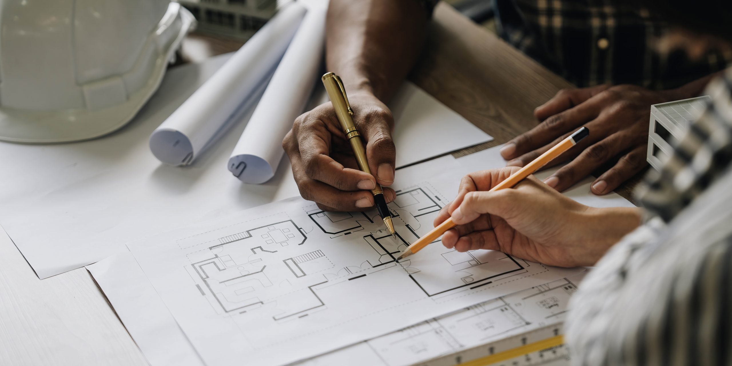 Construction engineers working at construction site with blueprint on table